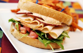 Sliced Turkey Sandwich with an Arugula Tomato Blend